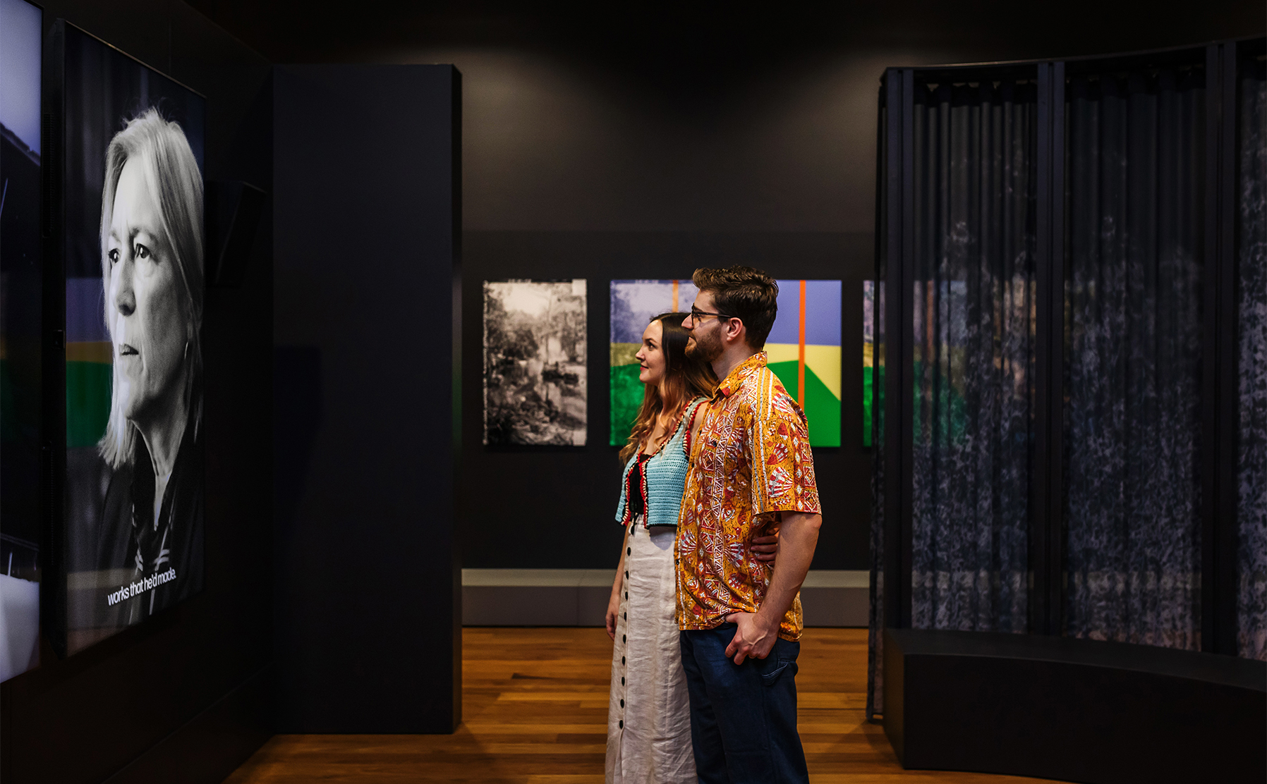 A couple smiling at a TV screen.