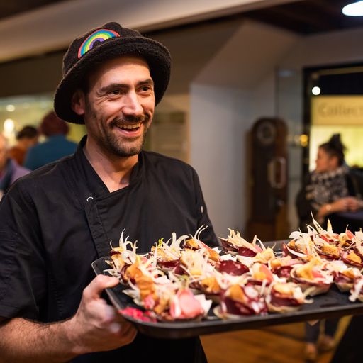 Chef Chris Jordan serving a plate of food with a smile